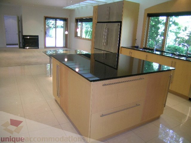 Bright kitchen with modern island, sleek countertops, and large windows. - 4215 Evergreen Ave, West Vancouver