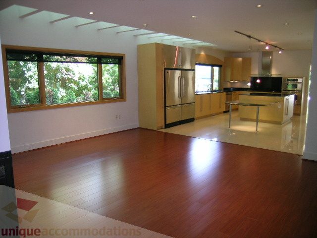 Bright kitchen with hardwood floors and large windows, showcasing a city view. - 4215 Evergreen Ave, West Vancouver