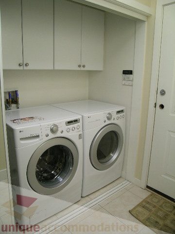 Laundry room with white appliances and cabinets, clean and organized. - 4215 Evergreen Ave, West Vancouver