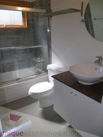 Modern bathroom with white sink, toilet, and granite countertop. - 4215 Evergreen Ave, West Vancouver