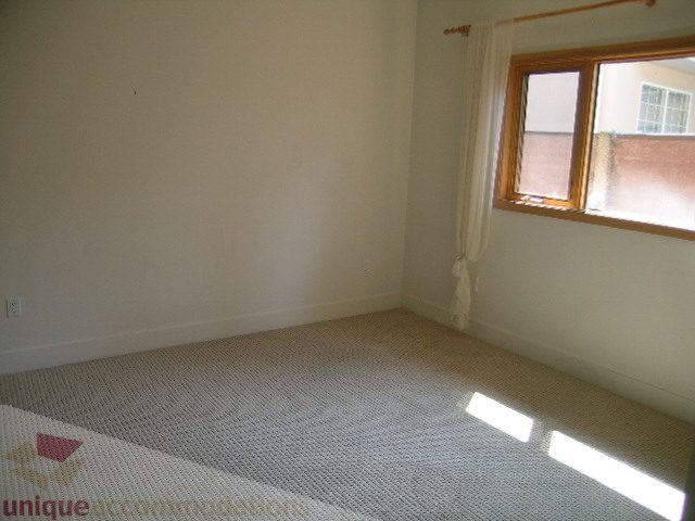 Bright bedroom with carpeted floor and large window. - 4215 Evergreen Ave, West Vancouver
