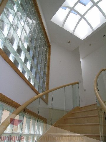 Staircase with glass railings and skylight, natural light flooding in. - 4215 Evergreen Ave, West Vancouver