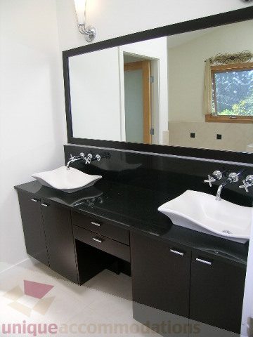 Bathroom with modern black countertops and white sinks. - 4215 Evergreen Ave, West Vancouver