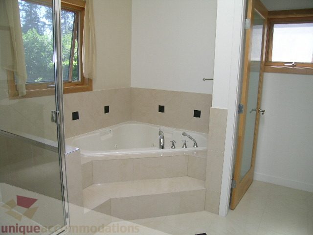 Spacious bathroom with beige countertops and large windows. - 4215 Evergreen Ave, West Vancouver