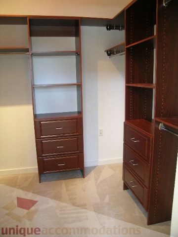 Spacious walk-in closet with wooden shelves and drawers. - 4215 Evergreen Ave, West Vancouver