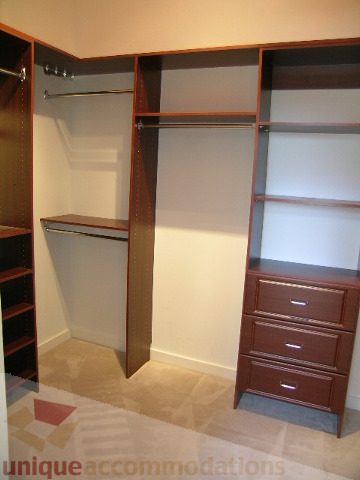 Furnished walk-in closet with built-in shelves and drawers, carpeted floor. - 4215 Evergreen Ave, West Vancouver