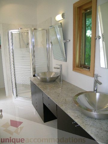 Bathroom with granite countertops and modern sink, large mirror, natural light from window. - 4215 Evergreen Ave, West Vancouver