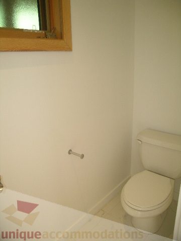 Bathroom with white toilet and small window. - 4215 Evergreen Ave, West Vancouver