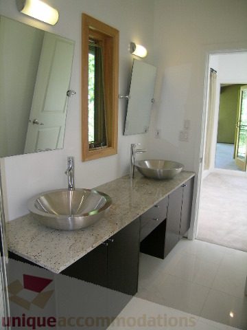 Modern bathroom with granite countertops and a sleek sink design. - 4215 Evergreen Ave, West Vancouver