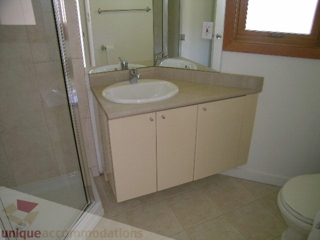 Bright bathroom with beige countertops and a corner sink. - 4215 Evergreen Ave, West Vancouver