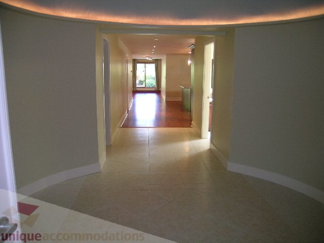 Spacious hallway leading to living area with hardwood floors and natural light. - 4215 Evergreen Ave, West Vancouver