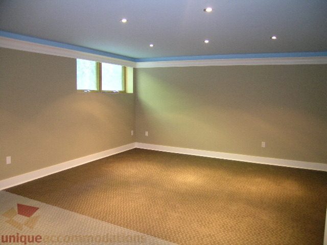 Bright living room with carpeted floors and recessed lighting. - 4215 Evergreen Ave, West Vancouver