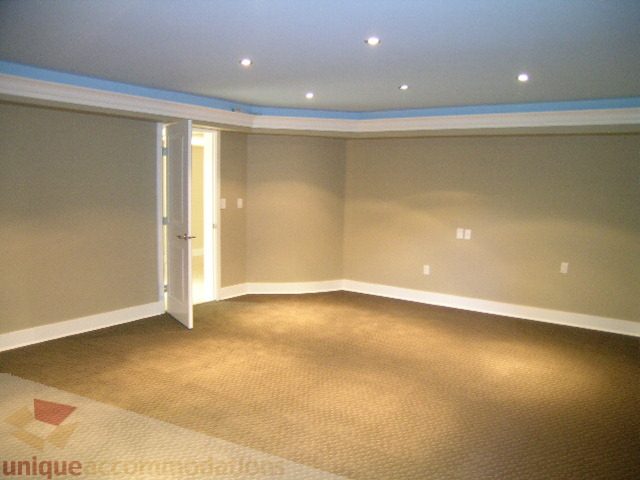Bright living room with built-in shelves and carpeted floor. - 4215 Evergreen Ave, West Vancouver