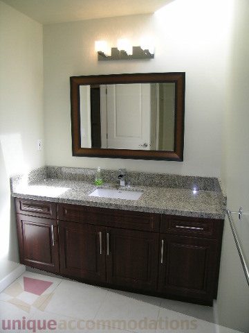 Bathroom with granite countertops and dark wood cabinets. - 4215 Evergreen Ave, West Vancouver
