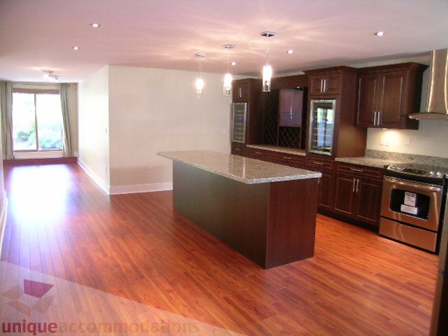 Bright kitchen with granite countertops, hardwood floors, and a wine fridge. - 4215 Evergreen Ave, West Vancouver