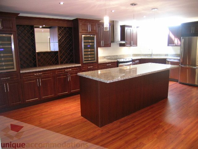 Bright kitchen with dark wood cabinets, granite countertops, and hardwood floors. - 4215 Evergreen Ave, West Vancouver