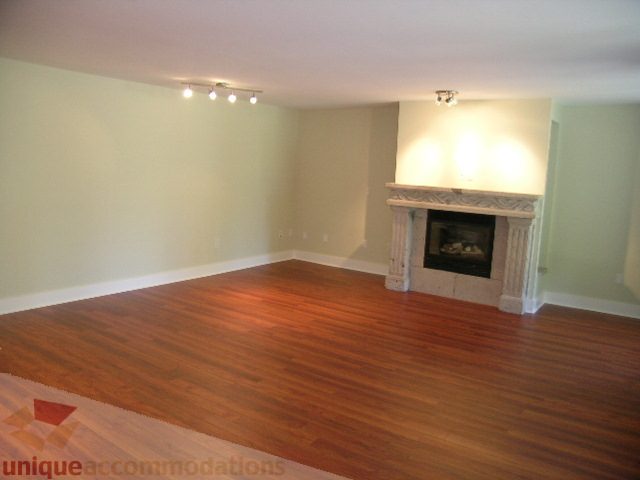 Spacious living room with hardwood floors and a fireplace. - 4215 Evergreen Ave, West Vancouver
