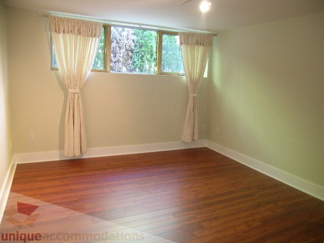 Spacious bedroom with hardwood floors and large windows. - 4215 Evergreen Ave, West Vancouver
