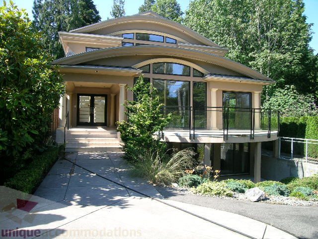 Spacious living room with large windows and outdoor access, surrounded by greenery. - 4215 Evergreen Ave, West Vancouver