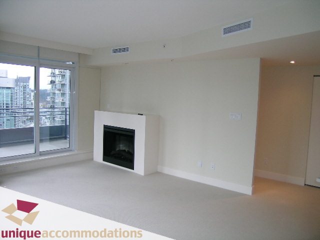 Bright living room with city view and modern fireplace, featuring a minimalist design. - 1805 -1205 W Hastings, Vancouver Downtown