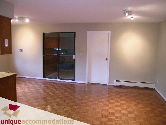 Bright living room with hardwood floors and a glass door leading to another room. - 5568 Greenleaf Road, West Vancouver