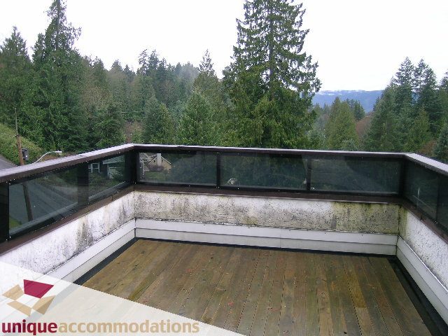 Furnished balcony with wooden deck and forest view. - 5568 Greenleaf Road, West Vancouver