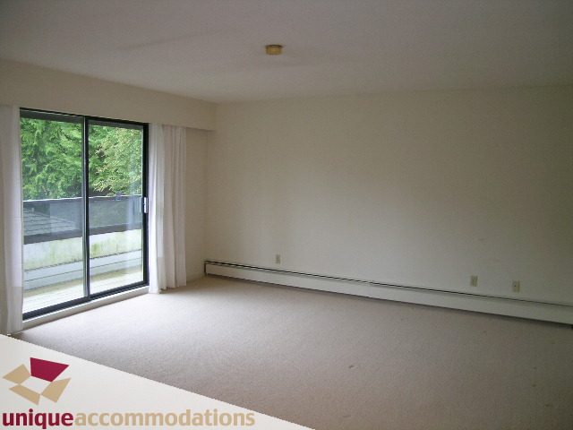 Spacious living room with sliding glass door and city view. - 5568 Greenleaf Road, West Vancouver