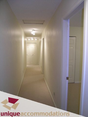 Furnished hallway with white walls and ceiling lights. - 5568 Greenleaf Road, West Vancouver
