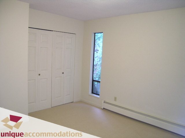 Bright bedroom with large closet and small window view. - 5568 Greenleaf Road, West Vancouver