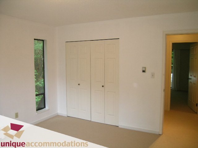 Spacious bedroom with large closet and window view. - 5568 Greenleaf Road, West Vancouver