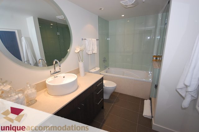 Furnished bathroom with modern sink, glass shower, and sleek countertop. - 1451 Howe Street, Vancouver Downtown