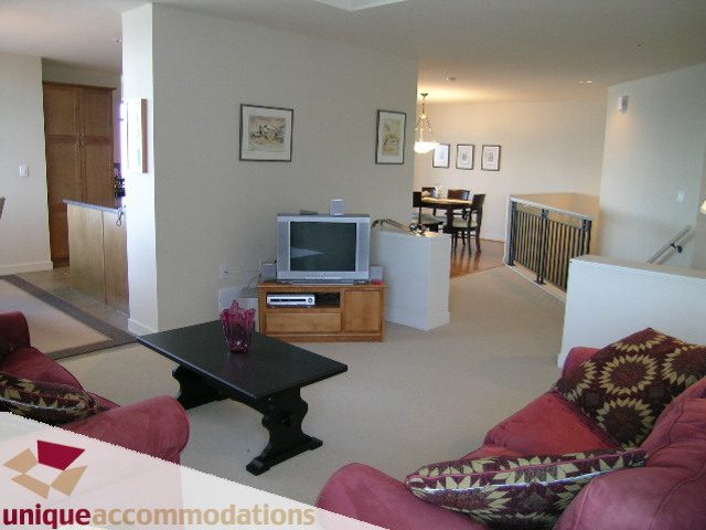 Spacious living room with hardwood floors, modern furniture, and a cozy corner for relaxation. - 8583 Seascape Lane, West Vancouver
