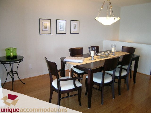 Elegant dining room with hardwood floors, framed artwork, and a modern chandelier. - 8583 Seascape Lane, West Vancouver