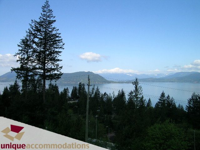 Spacious living room with stunning mountain and lake views. - 8583 Seascape Lane, West Vancouver