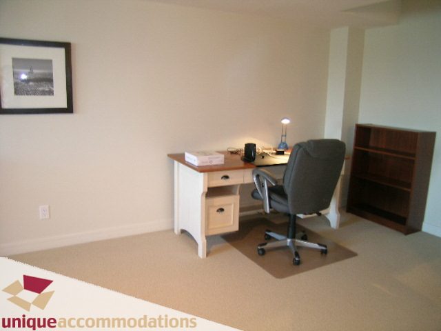 Furnished office space with a desk, two chairs, and a bookshelf, perfect for remote work. - 8583 Seascape Lane, West Vancouver