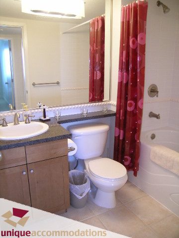 Bathroom with red floral shower curtain and dual sinks, offering a cozy and functional space. - 8583 Seascape Lane, West Vancouver