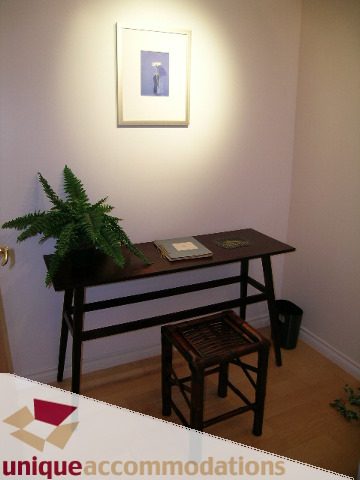 Spacious living room with wooden furniture, a fern, and a framed art piece on the wall. - 3401 - 1111 West Pender, Vancouver Downtown