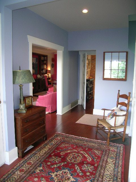 Furnished living room with hardwood floors, a red rug, and a wooden chair. - 1152 West 7th Ave, Vancouver West Side