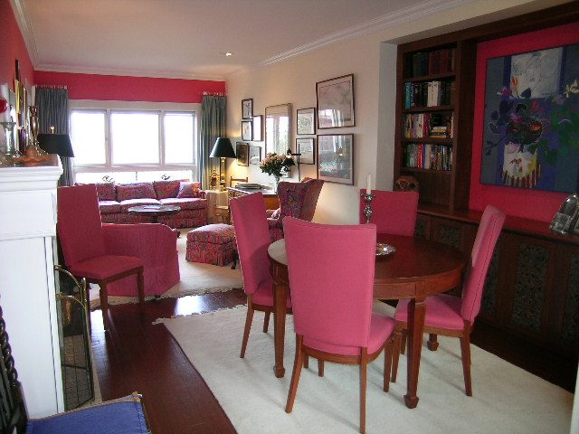 Furnished dining and living area with pink chairs, hardwood floors, and a bookshelf. - 1152 West 7th Ave, Vancouver West Side