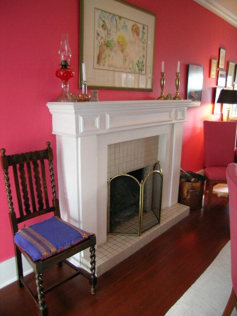 Bright living room with pink walls, white fireplace, and wooden chair. - 1152 West 7th Ave, Vancouver West Side
