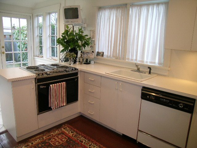 Bright kitchen with white cabinets, granite countertops, and hardwood floors. - 1152 West 7th Ave, Vancouver West Side