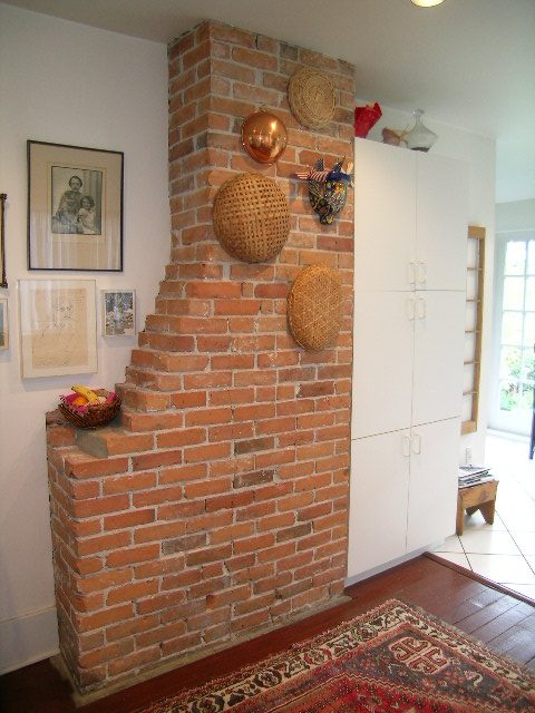 Living room with brick fireplace, wicker baskets, and white cabinets. - 1152 West 7th Ave, Vancouver West Side
