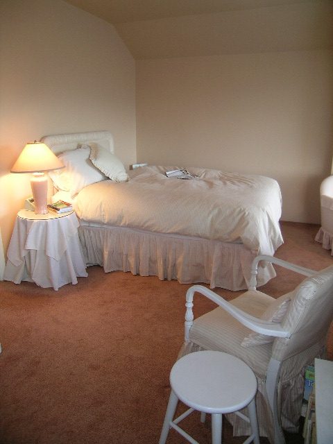 Furnished bedroom with a single bed, bedside table, and chair. - 1152 West 7th Ave, Vancouver West Side
