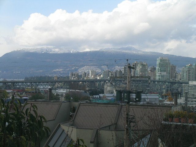 Bright living room with stunning city view and mountain backdrop. - 1152 West 7th Ave, Vancouver West Side