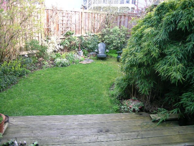 Furnished living room with wooden deck and lush green garden. - 1152 West 7th Ave, Vancouver West Side