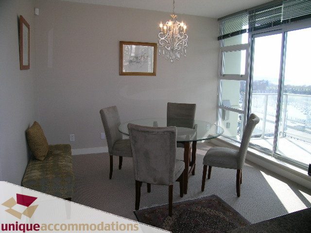 Furnished dining area with chandelier, city view, and modern decor. - 1905 - 638 Beach Cres, Vancouver Downtown