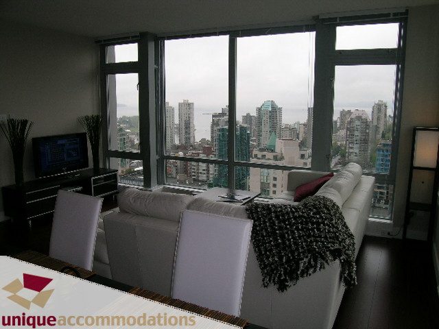 Living room with large windows showcasing a city view, modern furnishings, and a cozy ambiance. - 3104 - 1255 Seymour Street, Vancouver Downtown