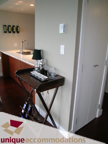 Bright kitchen with white countertops and dark wood flooring, modern decor. - 3104 - 1255 Seymour Street, Vancouver Downtown
