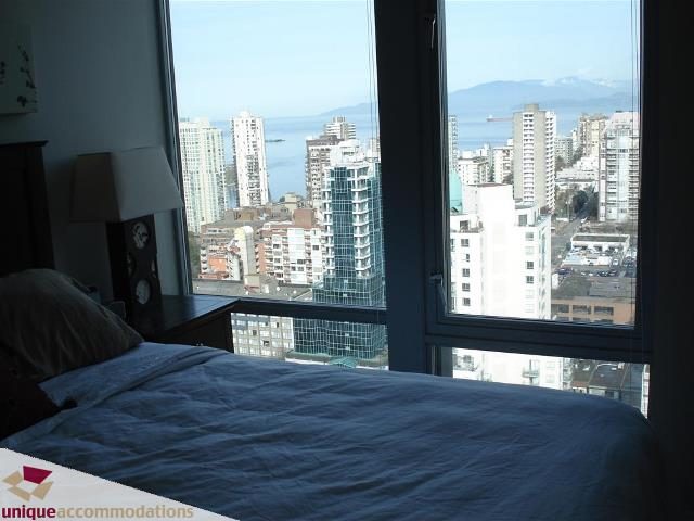 Furnished bedroom with a stunning city view and large windows. - 3104 - 1255 Seymour Street, Vancouver Downtown