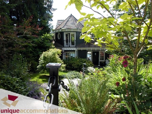 Spacious 7-bedroom house with a charming, dark green exterior and lush garden. - 3586 Creery Ave, West Vancouver